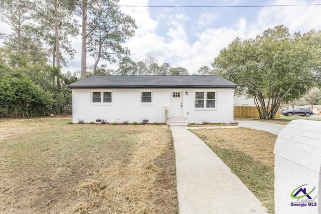 single story home with roof with shingles, fence, and a front lawn