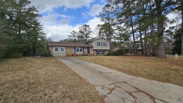 split level home featuring a front yard and brick siding