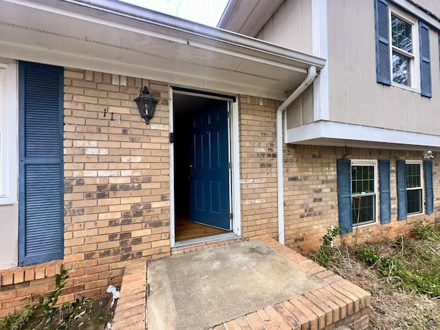 doorway to property with brick siding