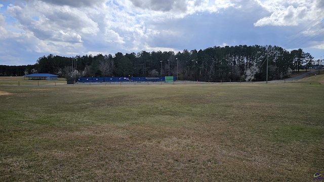 surrounding community with a forest view and a yard