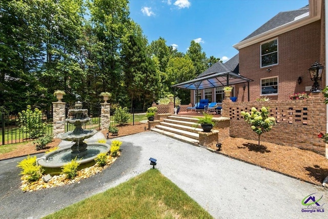 view of yard with a patio, a gazebo, fence, and driveway