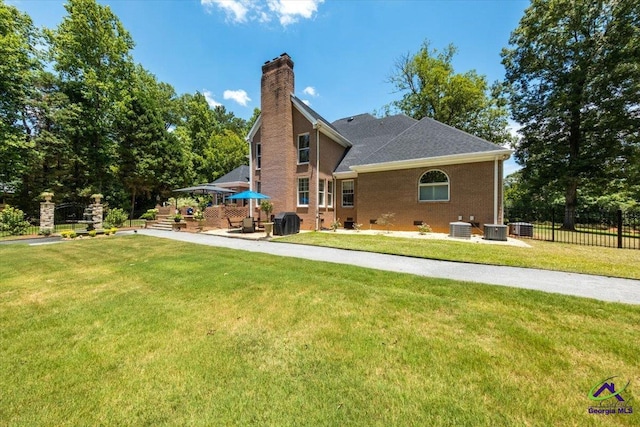 back of house with central AC, crawl space, a patio area, and a lawn