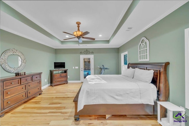 bedroom with baseboards, light wood-style flooring, access to exterior, a tray ceiling, and recessed lighting