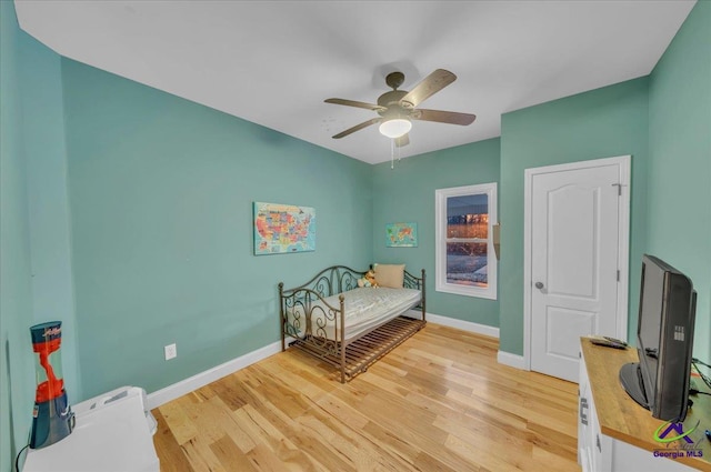 bedroom featuring light wood-style floors, baseboards, and a ceiling fan