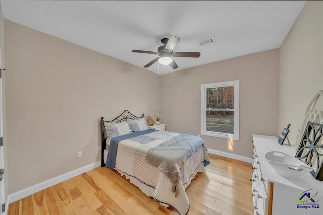 bedroom featuring light wood-style flooring, visible vents, and baseboards