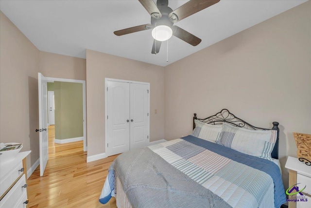 bedroom featuring light wood-style floors, ceiling fan, baseboards, and a closet