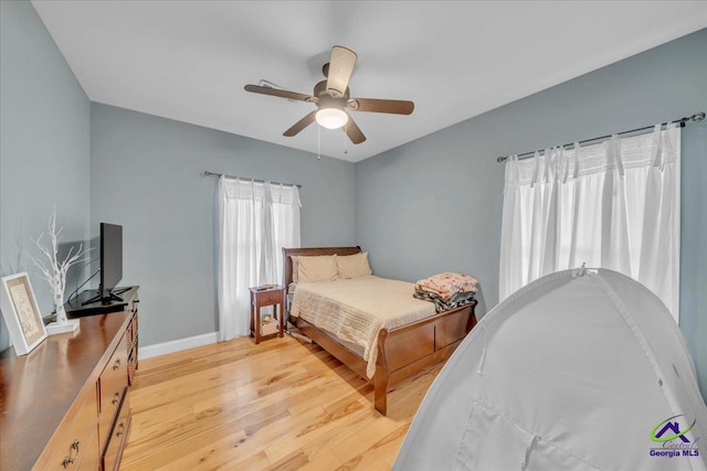 bedroom featuring light wood-style floors, ceiling fan, and baseboards