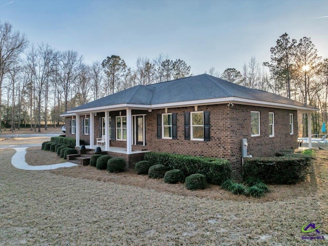 view of front of home with a porch and brick siding