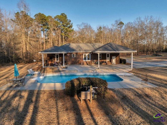 pool with a diving board and a patio