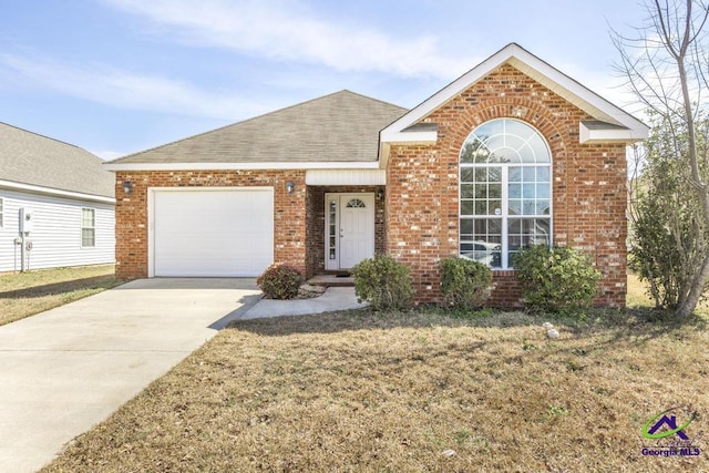 view of front facade with brick siding, a shingled roof, concrete driveway, a front yard, and a garage