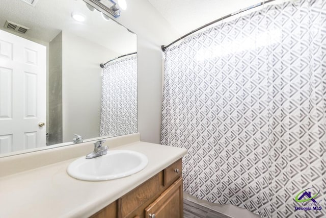 full bathroom with a shower with curtain, visible vents, and vanity