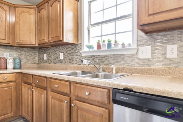 kitchen featuring light countertops, dishwasher, backsplash, and a sink