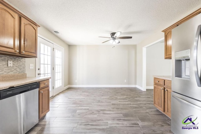 kitchen featuring stainless steel appliances, tasteful backsplash, light countertops, visible vents, and ceiling fan