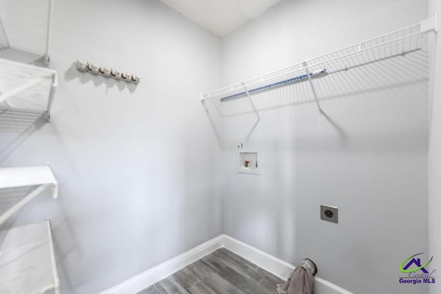 clothes washing area featuring hookup for a washing machine, hookup for an electric dryer, laundry area, wood finished floors, and baseboards