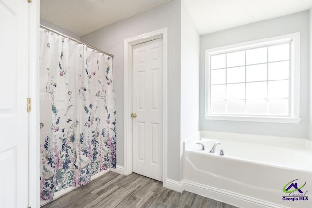 full bathroom featuring curtained shower, wood finished floors, a bath, and a healthy amount of sunlight