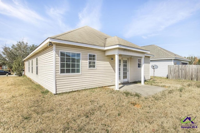 back of property with fence, a patio, and a yard