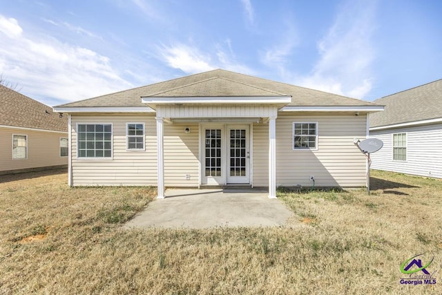 rear view of property featuring a yard, french doors, a patio area, and a shingled roof