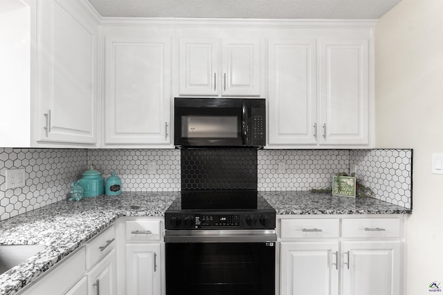 kitchen featuring black microwave, tasteful backsplash, range with electric stovetop, and white cabinetry