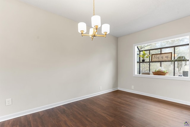 unfurnished room featuring a notable chandelier, dark wood-style floors, and baseboards