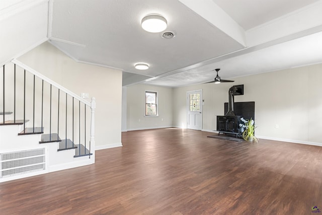 unfurnished living room featuring visible vents, stairway, wood finished floors, and a wood stove