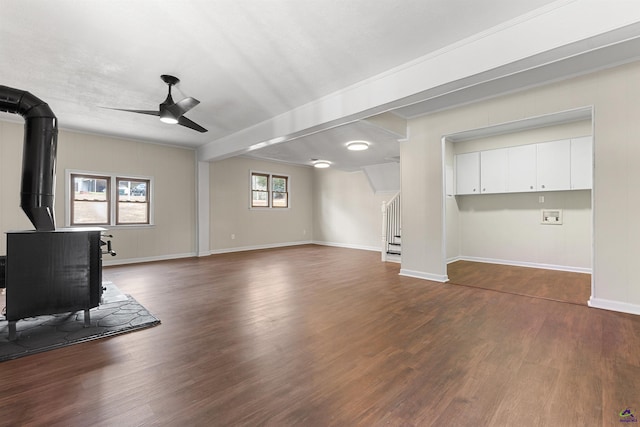 living room with a wood stove, a healthy amount of sunlight, and dark wood finished floors