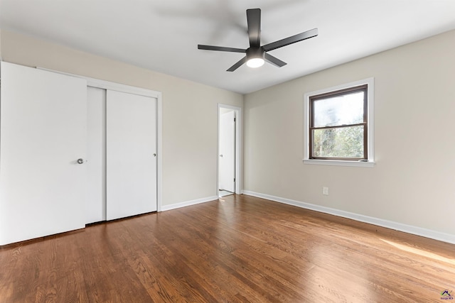 unfurnished bedroom featuring a ceiling fan, a closet, baseboards, and wood finished floors