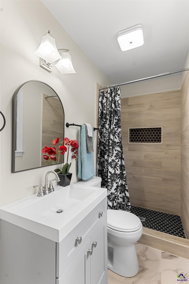 full bathroom with marble finish floor, tiled shower, vanity, and toilet