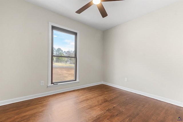 unfurnished room featuring ceiling fan, baseboards, and dark wood-style flooring