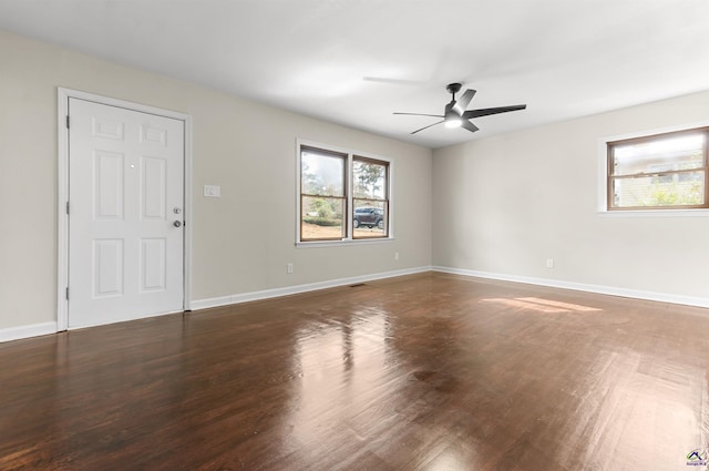 spare room featuring a ceiling fan, baseboards, and wood finished floors