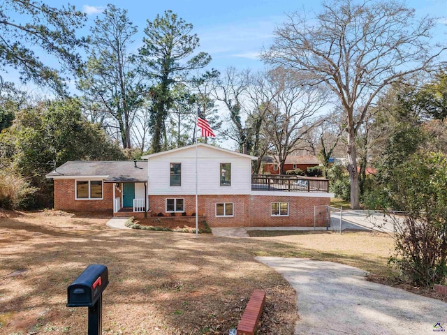 split level home with brick siding and fence