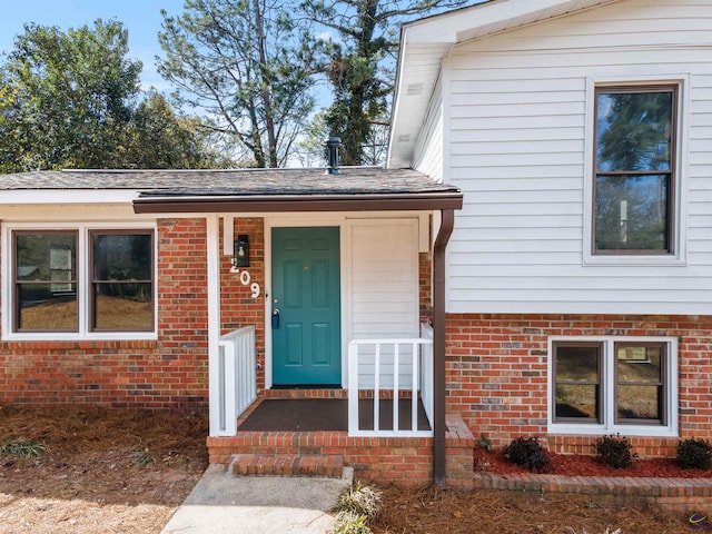 view of exterior entry featuring brick siding