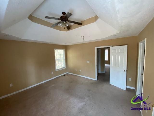 unfurnished bedroom featuring visible vents, baseboards, and a raised ceiling