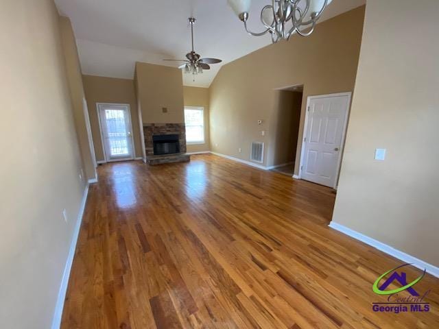 unfurnished living room with baseboards, visible vents, wood finished floors, and ceiling fan with notable chandelier