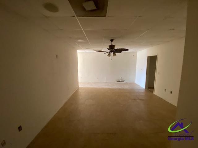 empty room with ceiling fan and concrete flooring