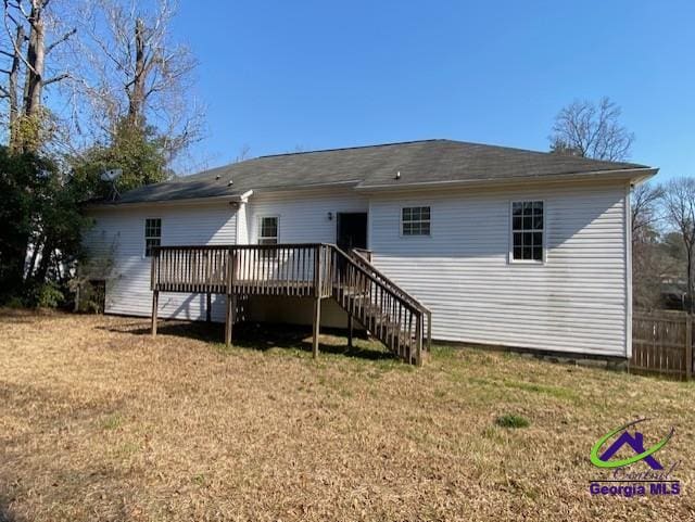 back of house featuring a yard, stairway, a wooden deck, and fence