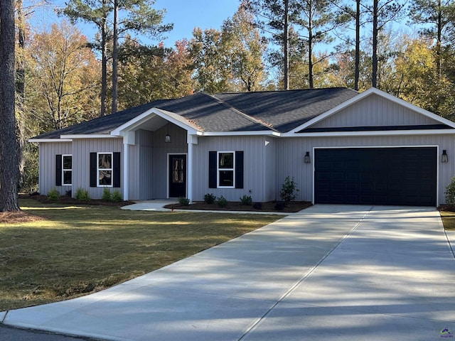 view of front of property with a garage, roof with shingles, driveway, and a front lawn