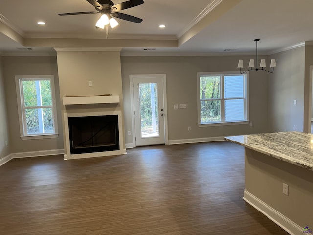 unfurnished living room featuring dark wood-style floors, a raised ceiling, a fireplace, and baseboards