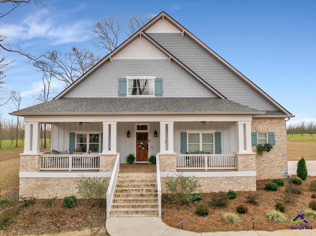 view of front of house with board and batten siding, covered porch, and a shingled roof