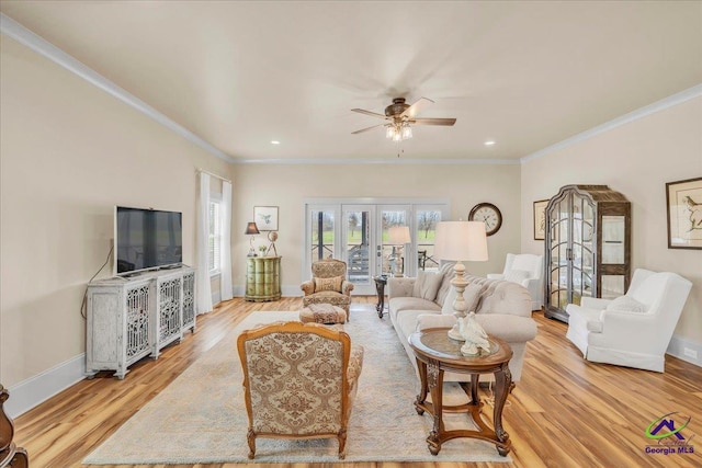 living room featuring light wood-style floors, crown molding, and baseboards