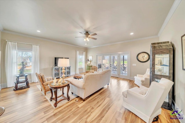 living area featuring french doors, light wood-type flooring, a ceiling fan, and crown molding