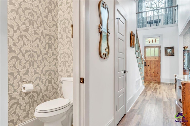 bathroom with visible vents, toilet, vanity, wood finished floors, and baseboards