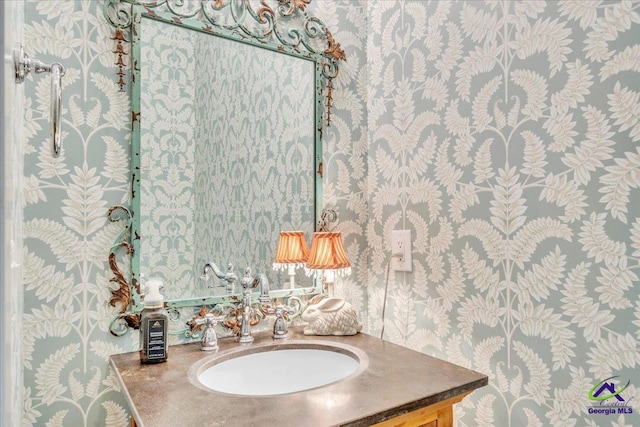 bathroom featuring vanity and wallpapered walls