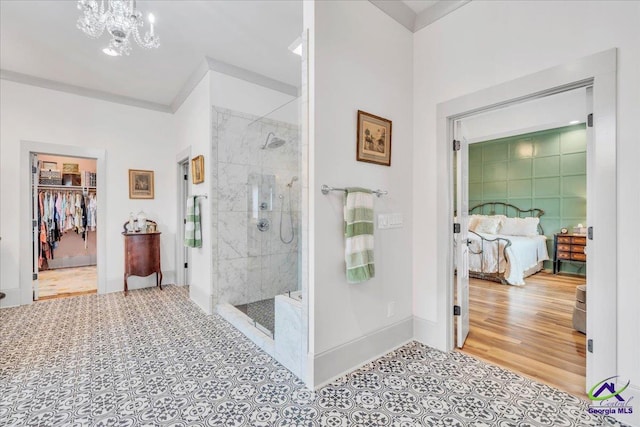 ensuite bathroom featuring connected bathroom, a shower stall, wood finished floors, a chandelier, and baseboards