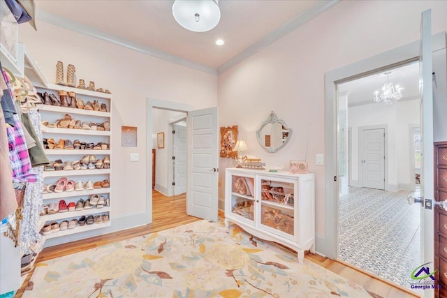 interior space featuring baseboards, a chandelier, crown molding, and wood finished floors