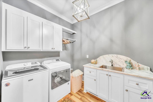 clothes washing area with separate washer and dryer, a sink, light wood-type flooring, cabinet space, and crown molding