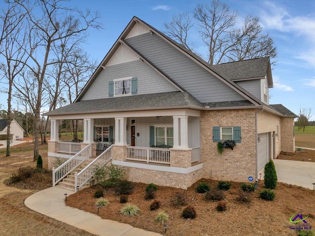 view of front of house featuring a porch, a garage, a shingled roof, brick siding, and concrete driveway