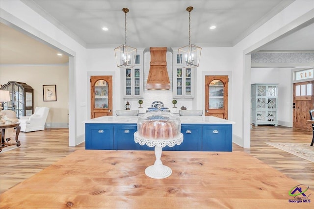 kitchen with blue cabinets, light countertops, and crown molding