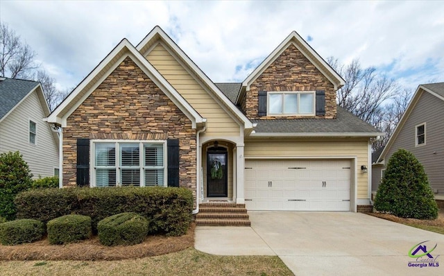 view of front of home with a garage, concrete driveway, a shingled roof, and stone siding