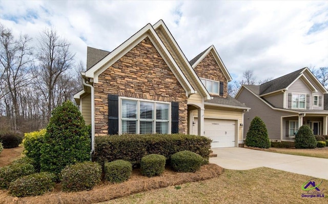 craftsman-style home with driveway, stone siding, and a garage