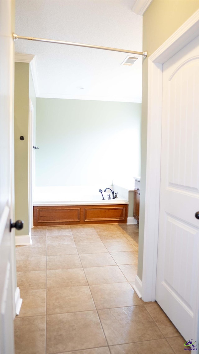 full bath featuring ornamental molding, a garden tub, visible vents, and tile patterned floors